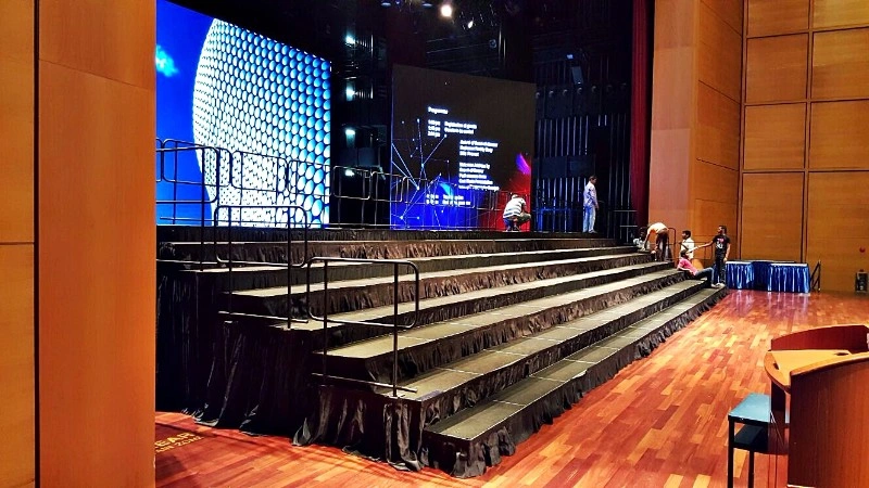 Custom 7-tier choir risers and stage setup with safety railings and large backdrop LED screen